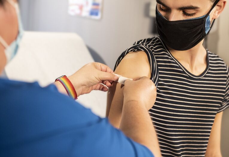 Ungdom som får plaster på arm etter vaksine